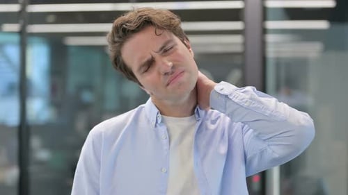 Young Adult Male Experiencing Neck Pain in Office