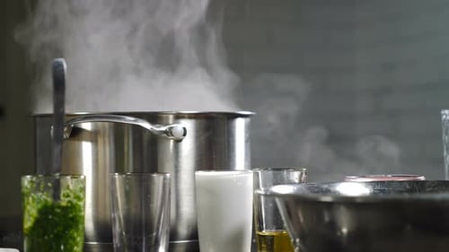 Chef adds pasta to steaming pot in kitchen