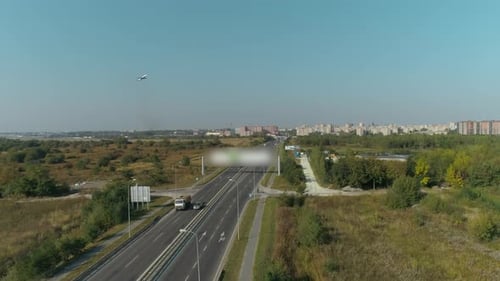 Passenger Plane Takes Off Into the Sky. Aerial View of Highway and Overpass in City.