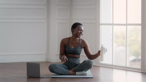Woman Drinks Water After Lotus Position Exercises