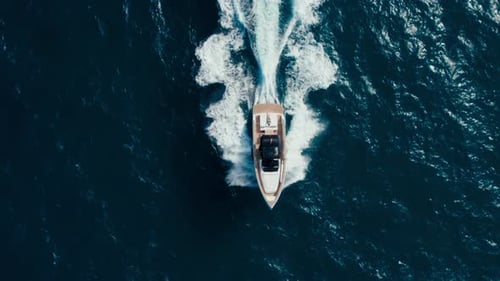 Aerial View of Boat Speeding Across Blue Ocean