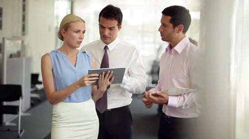 Team Collaborating on Tablet in Bright Modern Office