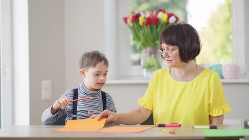 Woman and Boy Drawing with Pencils Indoors