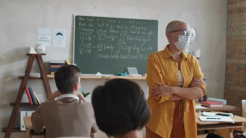 Teacher Giving Lecture in Classroom with Face Masks