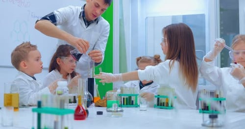 Teacher Explaining an Experiment to a High School Chemistry Class Together