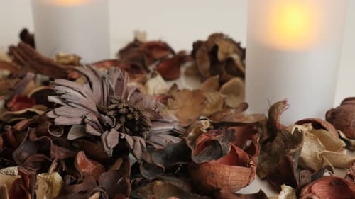 Light from LED candles and potpourri fragrant mixture close-up 4K 2160p 30fps UltraHD tilting foot