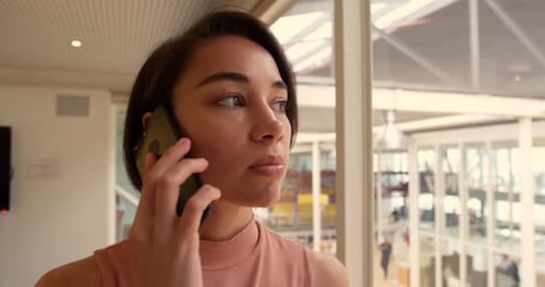Businesswoman talking on mobile phone in a modern office