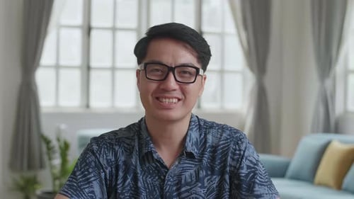 Man with Glasses Waving and Talking to Camera