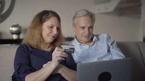 Positive Middle Aged Couple Paying Online