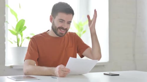 Man Reading Documents and Celebrating Good News