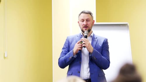 Redner im Wirtschaftsforum spricht mit dem Mikrofon und gibt Ratschläge.
