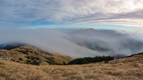 Mountains Shrouded in Mist Under Cloudy Sky