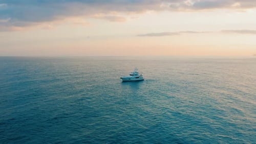 Boat Sailing on Blue Ocean at Sunset, Aerial View