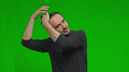 Close Up of a Casual Young Man Fixing His Hairstyle By Passing His Hand Through His Hair on Isolated