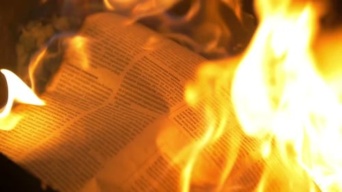 Zeitung in den Flammen des Feuers