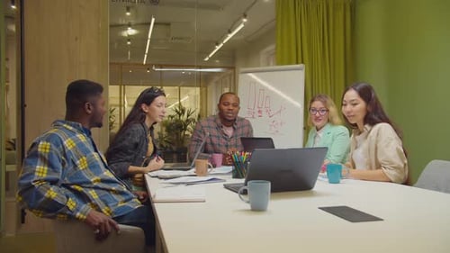 Diverse Team Celebrates Success in Office Meeting