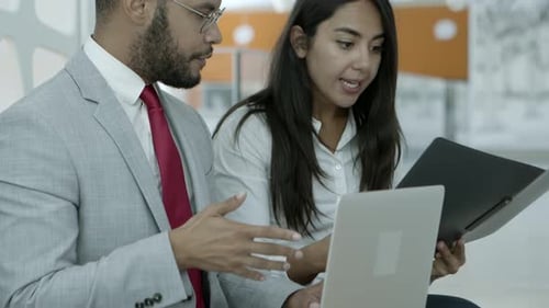Colleagues Working Together on Laptop in Modern Office