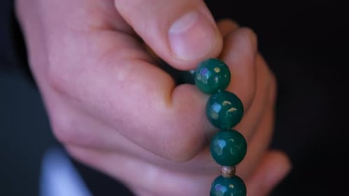 Gebetsperlen in Herren Hand auf dunkel