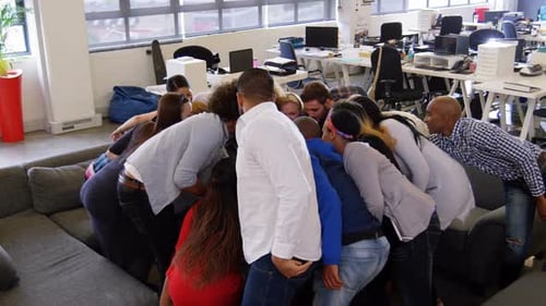 Happy business team stacking their hands together