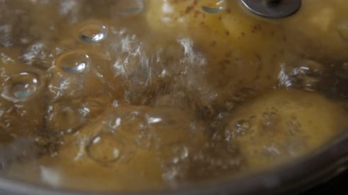 Potatoes Boiling Vigorously in a Covered Cooking Pot