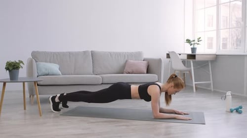 Woman Doing Plank Exercise on Mat Indoors