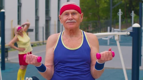 Senior Man Grandfather Doing Training Weightlifting Exercising with Dumbbells on Playground in Park