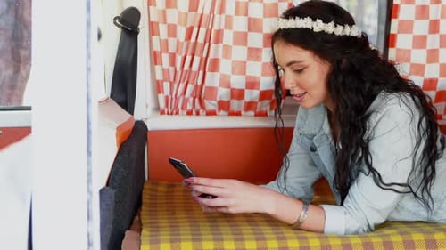Woman Using Mobile Phone Inside Camper Van