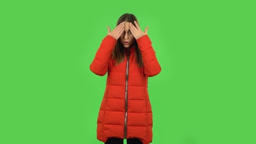 Belle fille dans une doudoune rouge se refroidit par sa main, souffrant de haute température