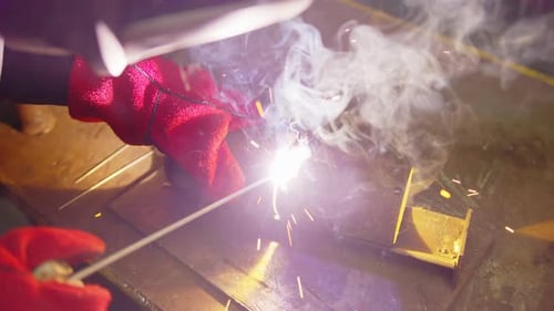 Metal Welder Working with Arc Welding Machine to Weld Steel at Factory While Wearing Safety