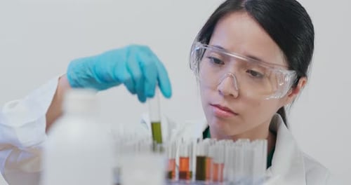 Female Scientist Examines Colorful Test Tube Samples