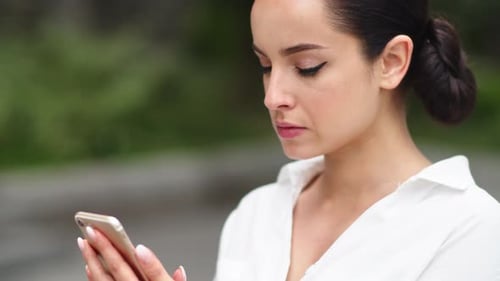 Woman Using Phone in Urban Setting
