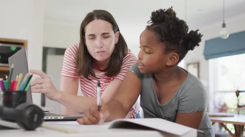 Adult Woman Helping Child with Homework on Laptop