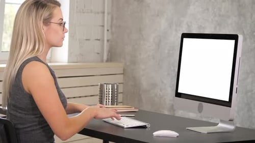 Woman Working at Computer with Blank White Screen
