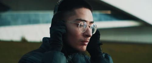 Young Adult Listening to Headphones in City