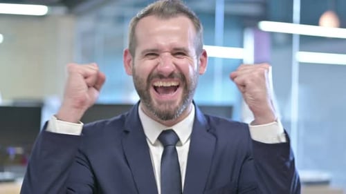 Excited Businessman Celebrating Good News at Office
