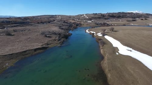 Flying Above Mountain River In Winter On A Sunny Day