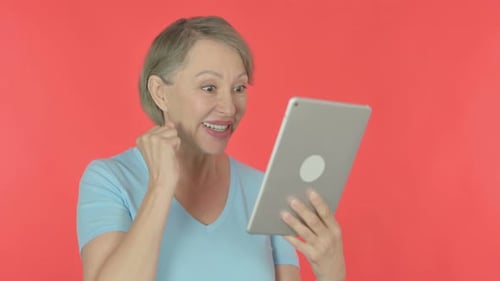 Excited Woman with Tablet on Red Background