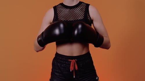 Young Woman Boxer Poses with Boxing Gloves