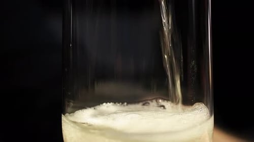 Verser une boisson pétillante dans un verre, en soulevant la mousse de carbonisation de l'air emprisonné - Fermer u