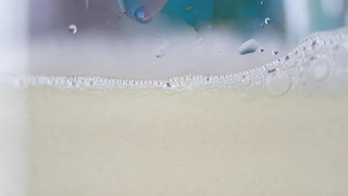 Golden Fizzy Liquid Filling a Glass