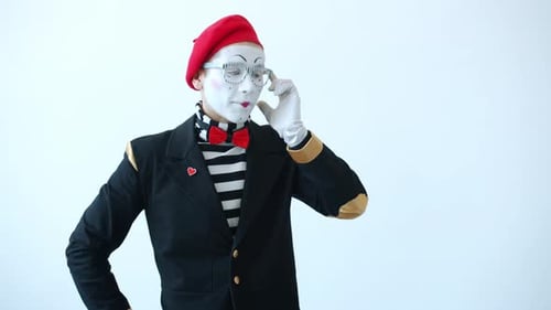 Porträt eines emotionalen Pantomime-Künstlers, der auf imaginärem Handy chattet und dann lächelt