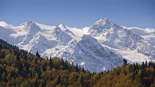 Clouds flowing through snowy mountains