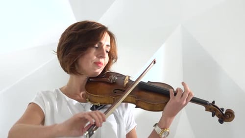 Two Women Playing Violins in White Studio