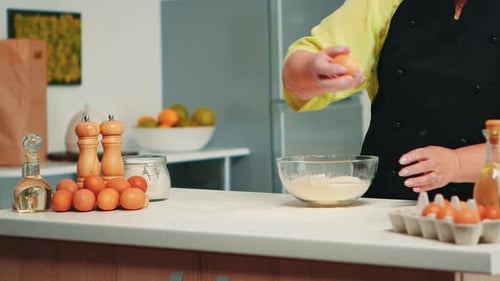 Adult Preparing Ingredients Breaking Eggs Into Bowl