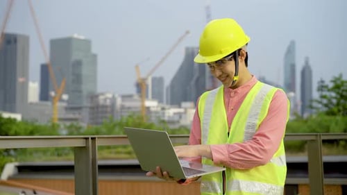Engineer or construction worker man is holding the laptop and working concentrated at building plan