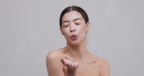 Beautiful Young Asian Girl Sending Blow Kiss at Camera