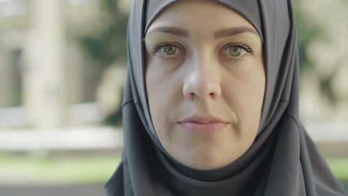 Nahaufnahme einer selbstbewussten attraktiven muslimischen Frau im Hijab, die im Freien in die Kamera blickt. Portrait von