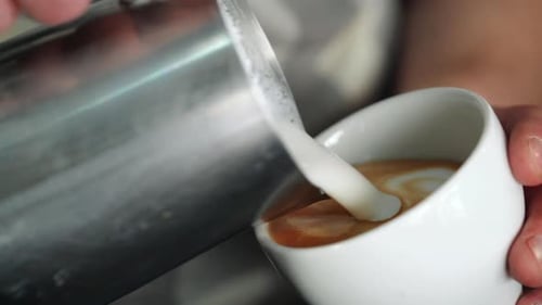 Barista making of cafe latte art, heart shape