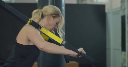Training with TRX Young Woman in the Gym Doing Fitness Workout with Training Straps Loop Equipment