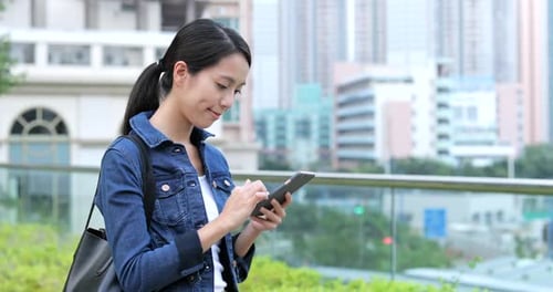 Woman Using Phone in Urban Setting